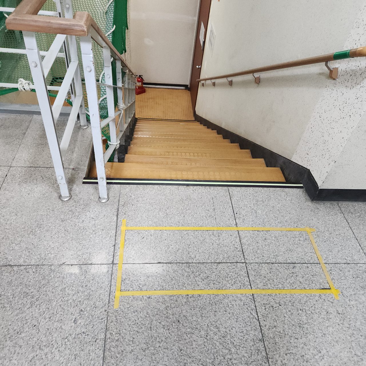 내려가는 계단 앞 테이프 표시