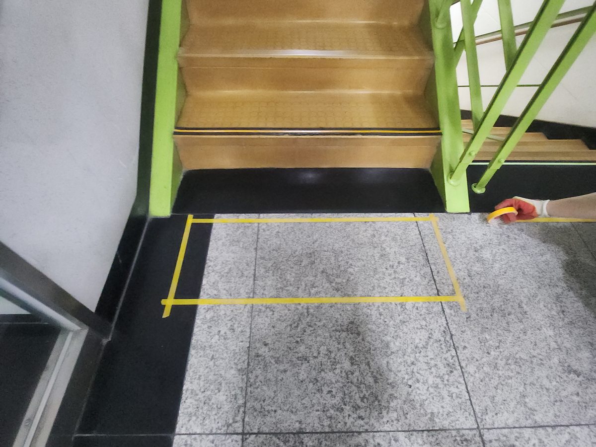 테이프로 표시한 블록 자리입니다. 계단 바로 앞에 노란 테이프를 둘렀습니다.